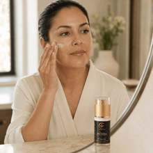 Cargar imagen en el visor de la galería, Mujer aplicando crema de día para manchas con FPS 50 en su rostro frente al espejo.